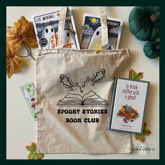 A Flatlay image of a natural canvas cotton tote bag with a 'spooky stories book club' open book with ghosts design. The bag is filled with ghost themed books